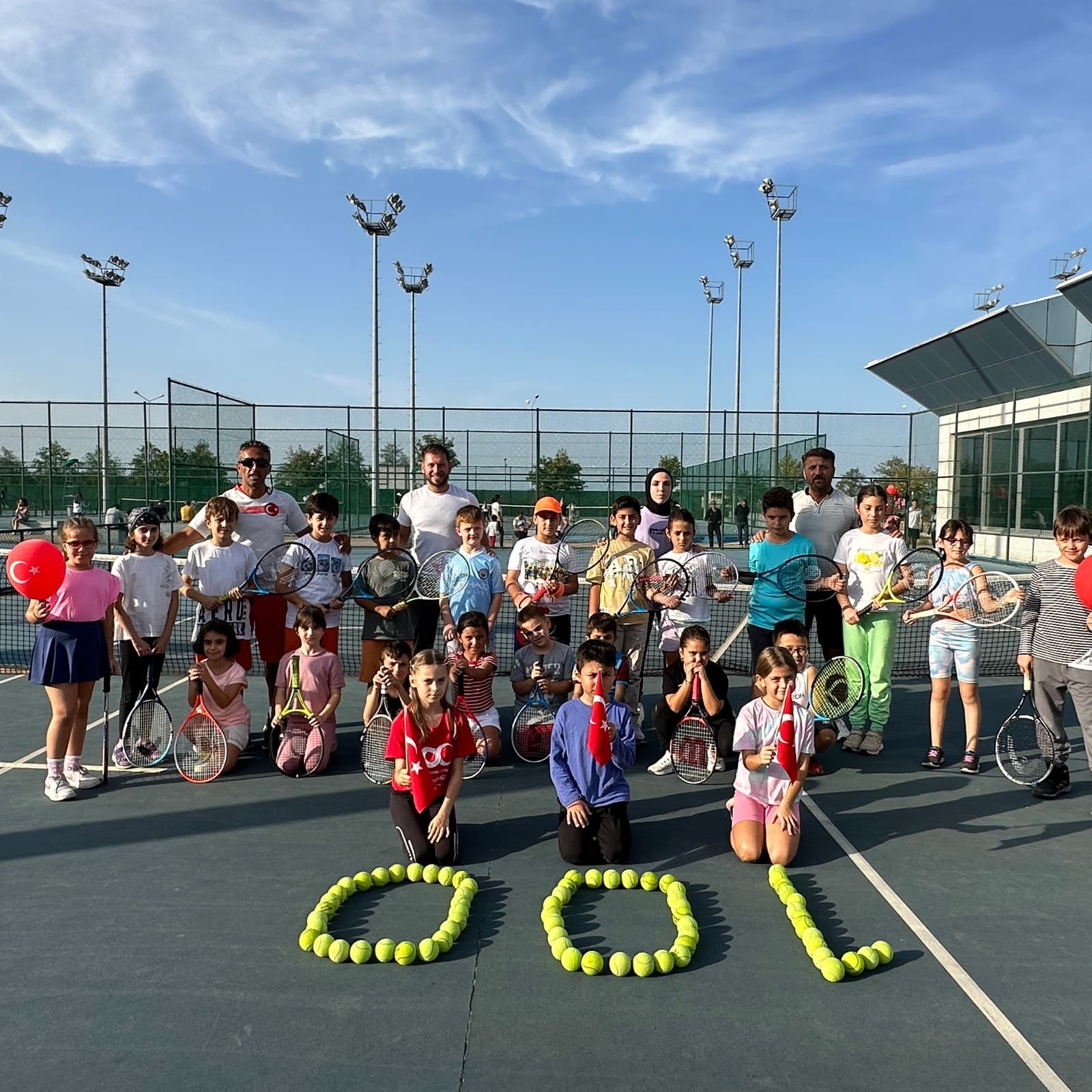 Trabzon Tenis Kulübü kortunda toplu fotoğraf veren çocuk grubu ve antrenörler
