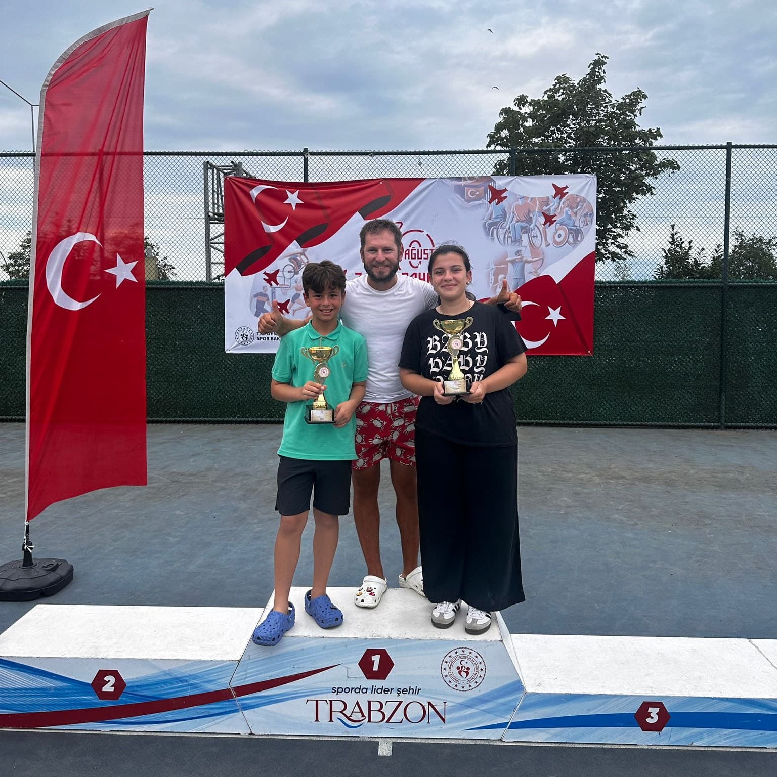 Türk bayraklarıyla süslü ödül töreni podyumunda kupalarını alan sporcular